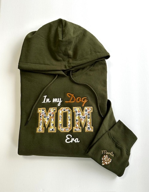 A front view of a hoodie jacket featuring the phrase "In My Dog Mom Era," showcasing a stylish and casual design