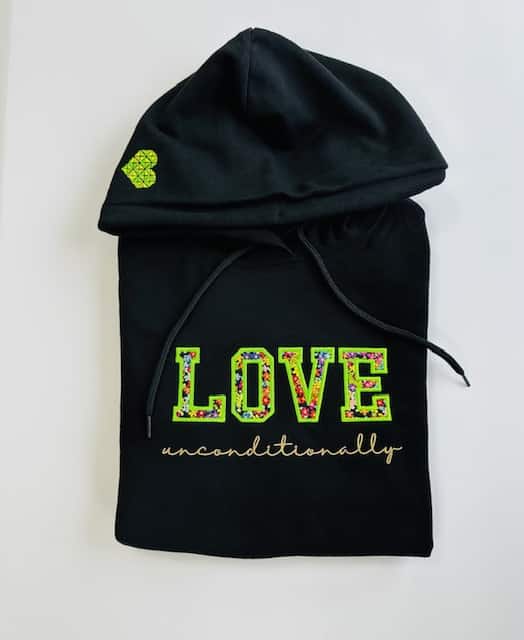 Front view of a black hoodie featuring the phrase "Love Unconditionally" in a stylish design